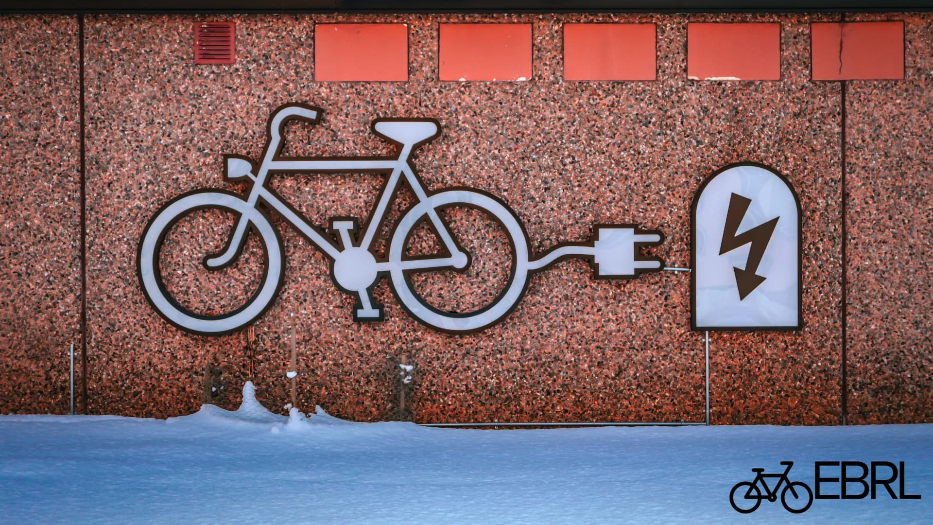 E-bike battery charging on a hard floor away from bedrooms and exit paths
